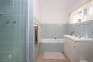 a bathroom with a tub and a sink at Stone Chimney Cottage in Hermanus +26 photos