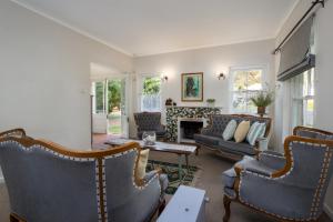 a living room with couches and a fireplace at Stone Chimney Cottage in Hermanus