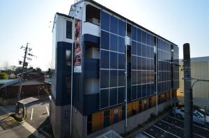 a building with solar panels on the side of it at Apartment Zen Hotel in Mizuho