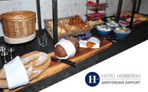 a table topped with lots of bread and other foods at Boutique Hotel Herbergh Amsterdam Airport FREE PARKING in Badhoevedorp