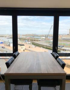 オーステンデにあるCosy, modern studio with an awesome view of Ostendの大きな窓のある部屋(木製テーブル付)