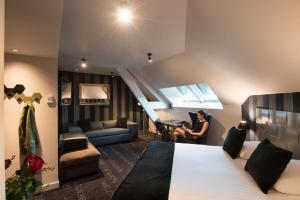 a woman sitting at a desk in a hotel room at Saint Georges Hotel & Spa in Chalon-sur-Saône