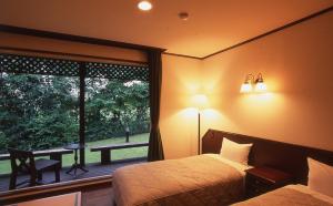 a bedroom with a bed and a window and a table at Canari in Nasu