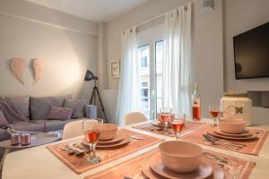 Un comedor con una mesa con platos y copas de vino. en "SunBow Earth"- Boutique new Apt in Dowtown Athens, en Atenas 52 fotos más