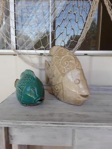 two vases sitting on a table with a fish at Bay Bell Cottage in Saint Leonards