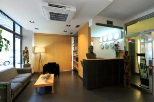 a lobby with a waiting room with a man sitting at a counter at Hotel Txarriduna in Elgóibar