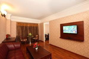 een woonkamer met een bank en een flatscreen-tv bij Cochin Legacy in Cochin
