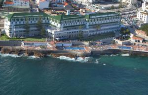 eine Luftansicht auf einen Strand mit Gebäuden und das Meer in der Unterkunft Vila Gale Ericeira in Ericeira