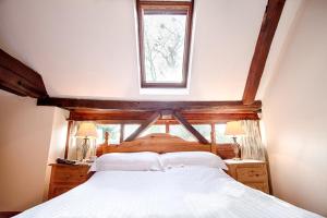 a bedroom with a large bed with a window at The Grove Cromer in Cromer