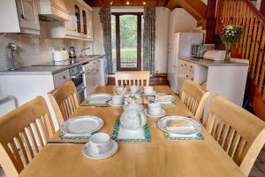 a kitchen with a wooden table with dishes on it at The Grove Cromer in Cromer