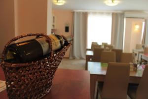 Una botella de vino en una cesta sobre una mesa en Villa Denta, en Nesebar