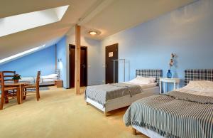 um quarto com 2 camas, uma mesa e uma sala de jantar em Aerohotel em Vilnius