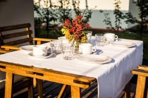 a table with plates and cups and a vase with flowers at Agriturismo Alba in Baone