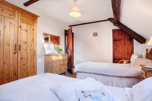 a bedroom with two beds and a dresser in a room at The Grove Cromer in Cromer