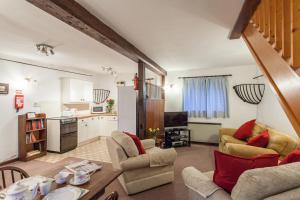 a living room with two couches and a kitchen at The Grove Cromer in Cromer