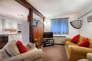 a living room with two couches and a kitchen at The Grove Cromer in Cromer