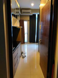 a room with a kitchen with a door and a hallway at Capitol Park Minimum Stay 2 Nights in Jakarta