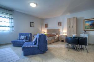 a bedroom with a bed and a blue couch and chairs at Castelomi in Podgorica
