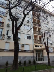 ein hohes weißes Gebäude mit Fenstern und Balkonen in der Unterkunft Apartman Ana in Subotica