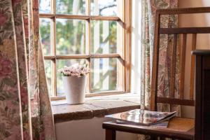 a vase of flowers sitting on a window sill at The Grove Cromer in Cromer