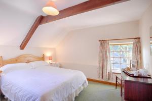 a bedroom with a large white bed and a window at The Grove Cromer in Cromer