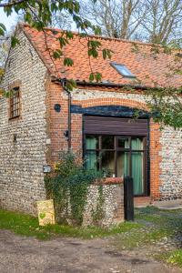 an old brick house with a window and a garage at The Grove Cromer in Cromer