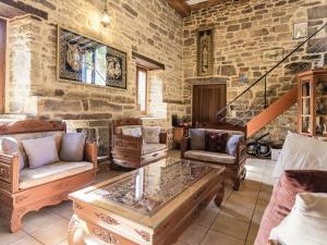 a living room with furniture and a stone wall at Modern Villa in S rilhac with Private Pool in Beynat