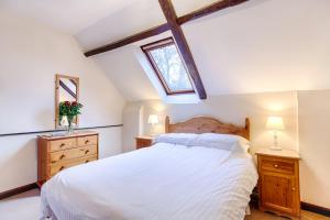 a bedroom with a white bed and a window at The Grove Cromer in Cromer