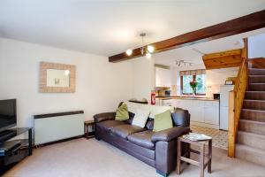 a living room with a couch and a kitchen at The Grove Cromer in Cromer