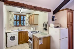 a kitchen with a white refrigerator and a dishwasher at The Grove Cromer in Cromer