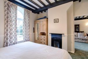 a bedroom with a white bed and a fireplace at The Grove Cromer in Cromer