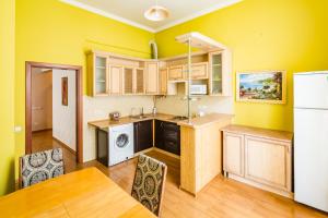 リヴィウにある2 Virmens'ka Apartmentの黄色の壁のキッチン(テーブル、椅子付)