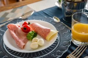 einen Teller mit Fleisch und Gemüse und ein Glas Orangensaft in der Unterkunft A casa di Alberto in Monopoli