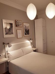 a bedroom with a white bed and two lights at Las Atarazanas - Design Hostal in Seville