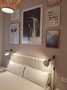 a bedroom with a bed and pictures on the wall at Las Atarazanas - Design Hostal in Seville