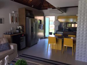 eine Küche mit einem Tisch und gelben Stühlen in einem Zimmer in der Unterkunft Bangalô luxo Carneiros Beach Resort in Praia dos Carneiros