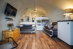 sala de estar con sofá y cama en una habitación en Deluxe Glamping Pod with Hot Tub, en Frodsham