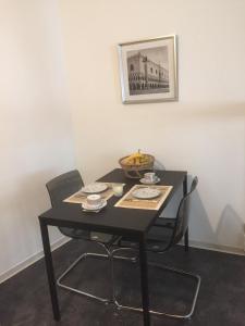 ein schwarzer Tisch mit Stühlen und eine Schale Obst darauf in der Unterkunft Belle Etage im Herzen der Altstadt in Bad Kreuznach