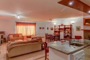 a kitchen and living room with a couch and a table at Casa Melo in Ericeira