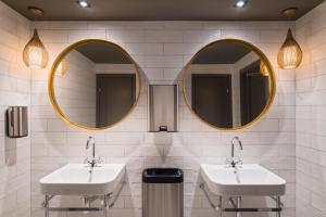 a bathroom with two sinks and a mirror at Clarion Collection Hotel Gabelshus in Oslo