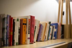 a row of books sitting on a shelf at Yeah Barcelona Hostel in Barcelona