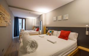 - une chambre avec 2 lits dotés de draps blancs et d'oreillers rouges dans l'établissement Yeah Barcelona Hostel, à Barcelone