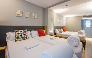 a room with two beds and a chair at Yeah Barcelona Hostel in Barcelona