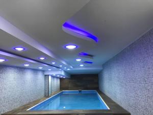 una piscina con luces azules en una habitación en Spectrums Al Salamah Jeddah, en Yeda