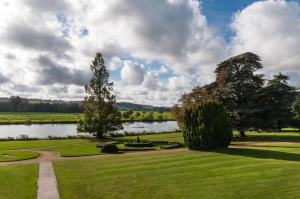 einen Park mit einem See, Bäumen und einem Feld in der Unterkunft Greenlands Hotel in Henley on Thames