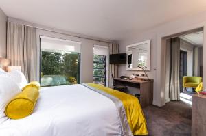 a hotel room with a bed and a desk and a window at Greenlands Hotel in Henley on Thames +41 photos