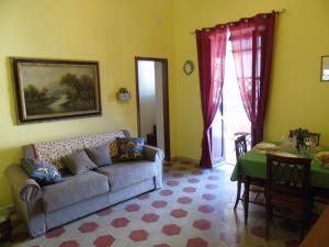 uma sala de estar com um sofá e uma mesa em Casa Arenella em Palermo
