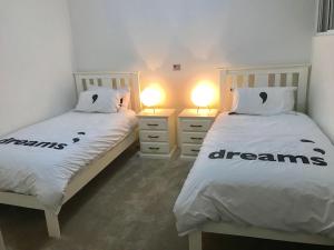 2 camas individuales en una habitación con 2 lámparas en Joondalup Apartment, en Perth