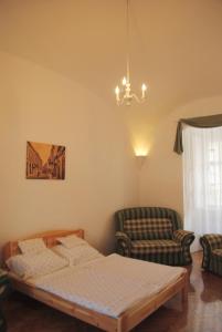 a bedroom with a bed and a couch and a chair at Dobó Téri Apartman in Eger