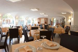 un ristorante con tavoli e sedie in una stanza di Hotel La Pergola a Santa Maria di Castellabate